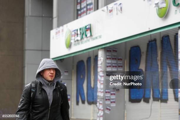 People pass by a graffiti-covered blocked Sberbank branch in Kyiv, Ukraine, March 19, 2017. Supporters and members of Azov nationalistic battalion's...