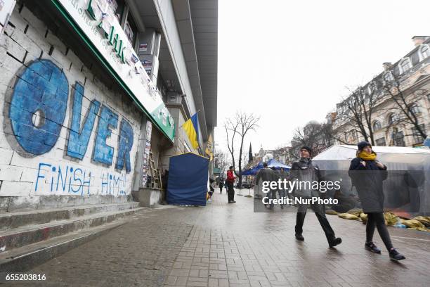 People pass by a graffiti-covered blocked Sberbank branch in Kyiv, Ukraine, March 19, 2017. Supporters and members of Azov nationalistic battalion's...