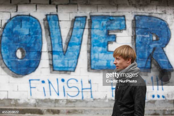 Man passes by a graffiti-covered blocked Sberbank branch in Kyiv, Ukraine, March 19, 2017. Supporters and members of Azov nationalistic battalion's...