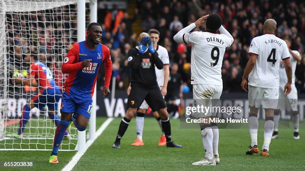 Christian Benteke of Crystal Palace celebrates as Troy Deeney of Watford despairs after scoring an own goal during the Premier League match between...