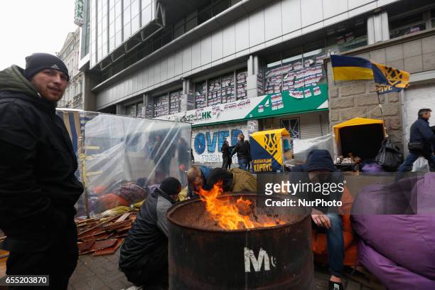 Activists blocking Sberbank branch warm themselves around firepit set next to a financial institution in Kyiv, Ukraine, March 19, 2017. Supporters...