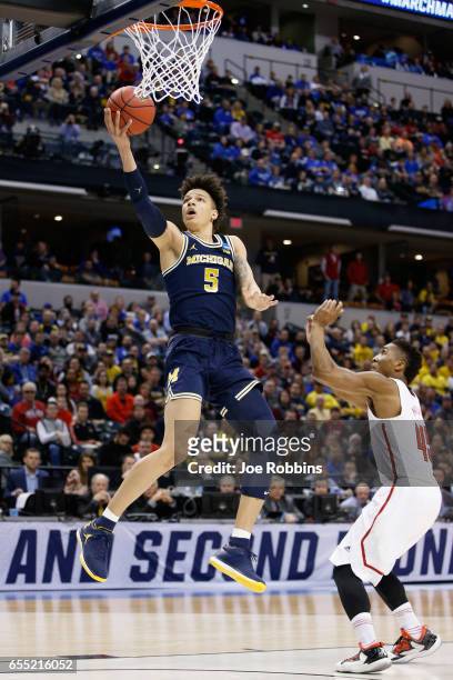 Wilson of the Michigan Wolverines lays it up for a shot against Donovan Mitchell of the Louisville Cardinals in the first half during the second...