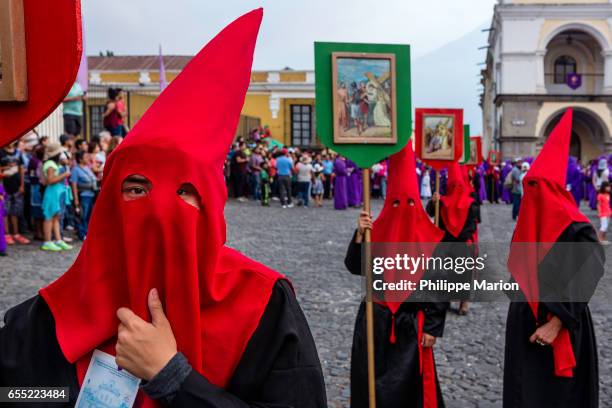 penitents wearing hoods in procession during holy week (semana santa) - antigua guatemala - holy week banner stock pictures, royalty-free photos & images