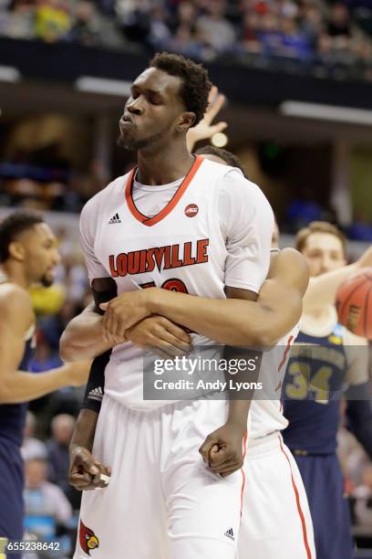 Mangok Mathiang of the Louisville Cardinals is hugged by a teammate as he reacts against the Michigan Wolverines in the first half during the second...