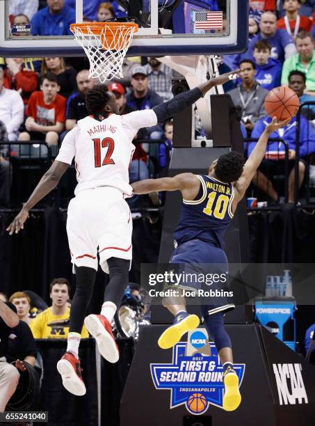 Mangok Mathiang of the Louisville Cardinals attempts to block a shot by Derrick Walton Jr. #10 of the Michigan Wolverines in the second half during...