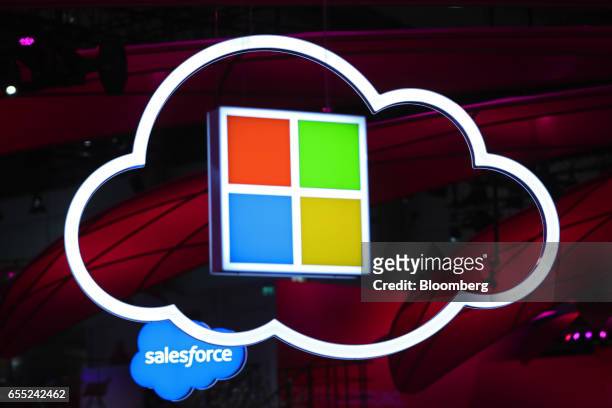 Salesforce.Com Inc., left, and a Microsoft Corp. Logo, center, hang beside an illuminated icloud icon at the CeBIT 2017 tech fair in Hannover,...