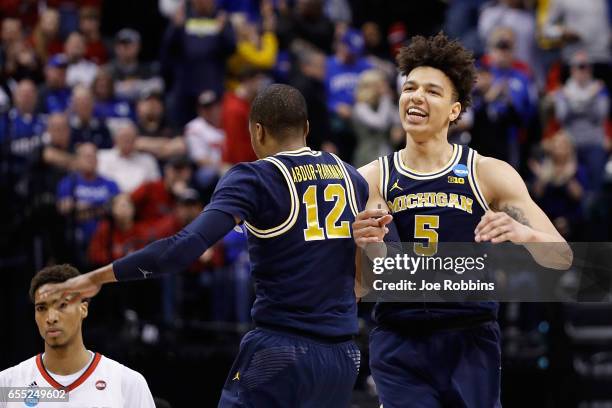 Muhammad-Ali Abdur-Rahkman and D.J. Wilson of the Michigan Wolverines celebrate in the second half against the Louisville Cardinals during the second...
