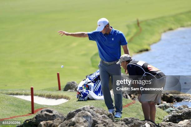 Lucas Glover of the United States takes a drop on the third hole as caddie Don Cooper looks on during the final round of the Arnold Palmer...