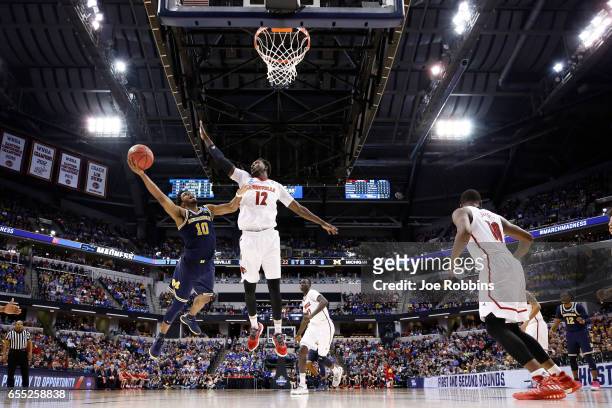 Derrick Walton Jr. #10 of the Michigan Wolverines drives to the basket against Mangok Mathiang of the Louisville Cardinals during the second round of...