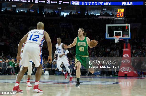 Kelly Olynyk of the Boston Celtics dribbles the ball against Gerald Henderson and Robert Covington of the Philadelphia 76ers in the second quarter at...