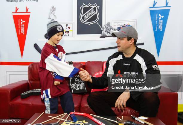 Young fan greets former Ottawa Senators Chris Phillips at the Mitsubishi Electric activation tent installation at NHL Centennial Fan Arena at the...