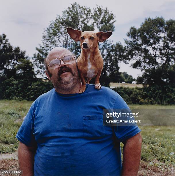 man with corgi on shoulder - all you need is love stockfoto's en -beelden