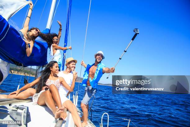 grupo de amigos divirtiéndose y haciendo selfie en yate - navegación en yate fotografías e imágenes de stock