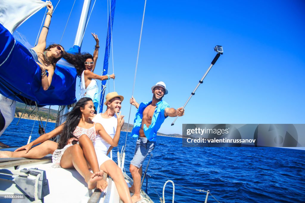 Group of friends having fun and making selfie on yacht