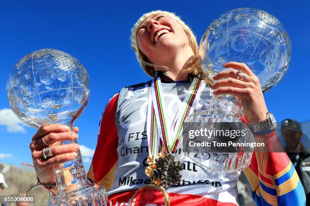 Mikaela Shiffrin of the United States celebrates with the globes for being awarded the overall season ladies' champion and lasies' season slalom...