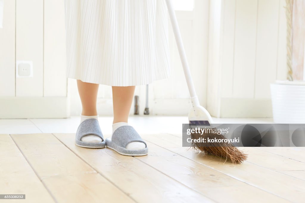 Smiling Asian woman cleaning the room