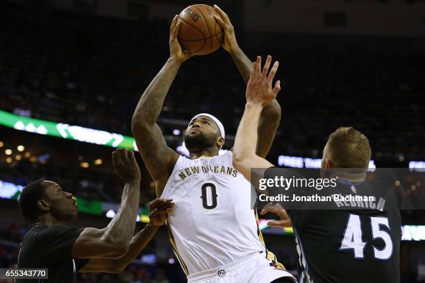 DeMarcus Cousins of the New Orleans Pelicans shoots over Gorgui Dieng of the Minnesota Timberwolves and Cole Aldrich during the first half of a game...