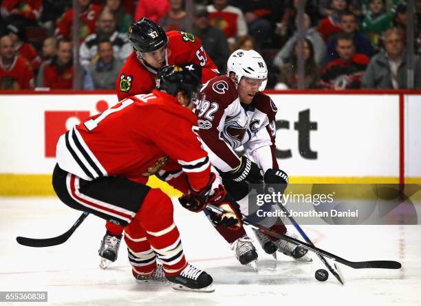 Gabriel Landeskog of the Colorado Avalanche tries to get off a shot between Brian Campbell and Trevor van Riemsdyk of the Chicago Blackhawks at the...