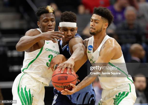 Teammates Dylan Ennis and Tyler Dorsey of the Oregon Ducks go after a loose ball against E.C. Matthews of the Rhode Island Rams during the second...