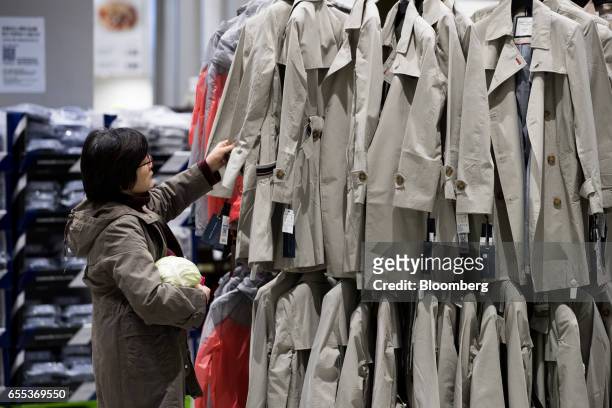 Customer inspects a coat at an E-Mart Inc. Traders store in the Starfield Hanam shopping complex, operated by Shinsegae Co., in Hanam, Gyeonggi,...