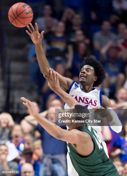 Kansas Jayhawks guard Josh Jackson knocks the ball away from Michigan State Spartans forward Nick Ward as they battle for a rebound in the first half...