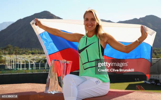 Elena Vesnina of Russia holds the Russian flag along with her trophy as she poses for photographs after her three set victory against Svetlana...