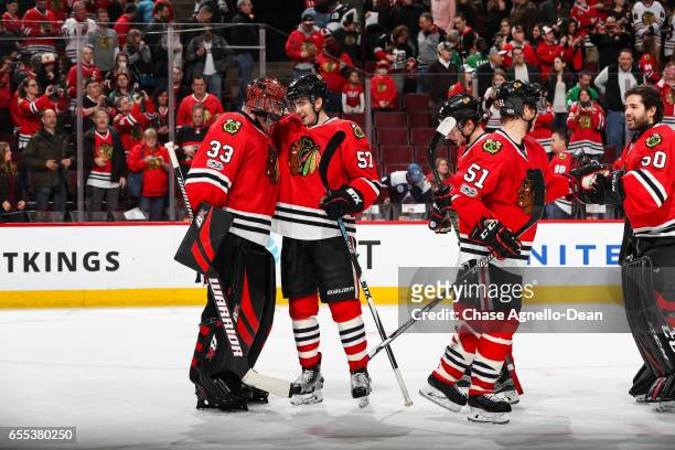 Goalie Scott Darling and Trevor van Riemsdyk of the Chicago Blackhawks celebrate after defeating the Colorado Avalanche 6-3 at the United Center on...