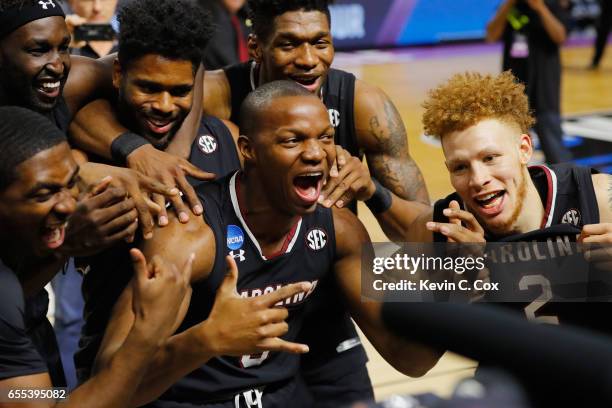 TeMarcus Blanton and Hassani Gravett of the South Carolina Gamecocks celebrate with teammates after defeating the Duke Blue Devils 88-81 in the...