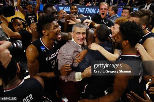 Head coach Frank Martin of the South Carolina Gamecocks celebrates with players after defeating the Duke Blue Devils 88-81 in the second round of the...