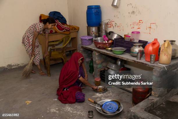 Women perform daily chores in a room alloted to their family at the transit camp that houses the residents of the Kathputhli Colony in New Delhi. The...