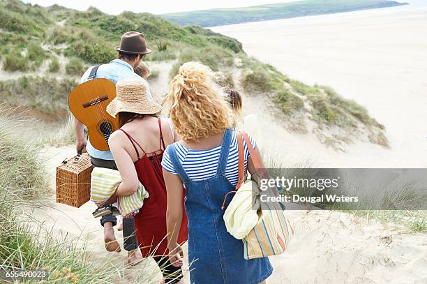 friends walking to beach through dunes. - beach towel stock pictures, royalty-free photos & images