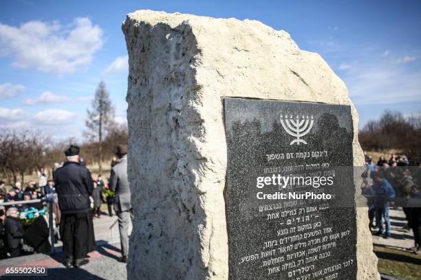 People gathered by a monument of Jewish victims at the former Plaszow concentration camp during the March of Remembrance commemorating 74....