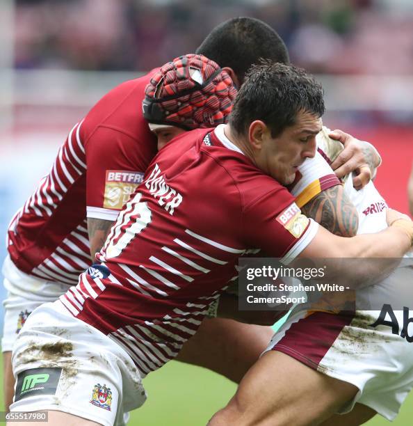 Huddersfield Giants' Sam Rapira is tackled by Wigan Warriors' Ben Flower and Frank-Paul Nu'uausala during the Betfred Super League Round 5 match...