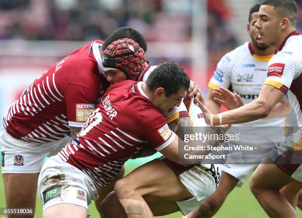 Huddersfield Giants' Sam Rapira is tackled by Wigan Warriors' Ben Flower and Frank-Paul Nu'uausala during the Betfred Super League Round 5 match...