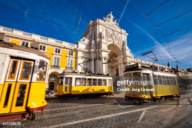 lisbon trams at praca do comercio - lisbonne photos et images de collection