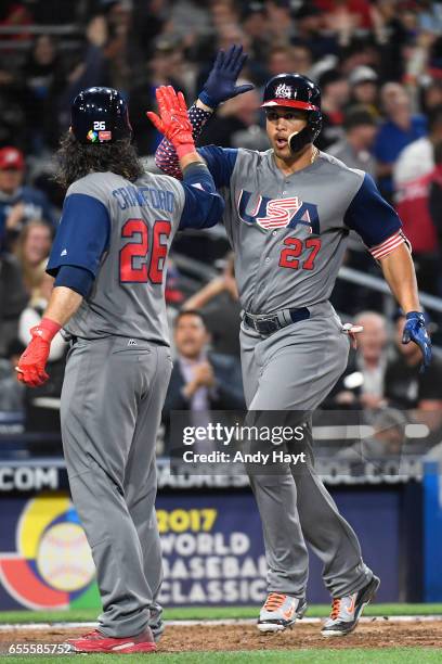 Giancarlo Stanton of Team USA is congratulated by teammate Brandon Crawford after hitting a two-run home run in the top of the fourth inning of Game...