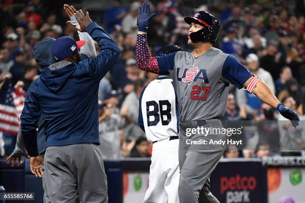 Giancarlo Stanton of Team USA is congratulated by teammates after hitting a two-run home run in the top of the fourth inning of Game 6 of Pool F of...