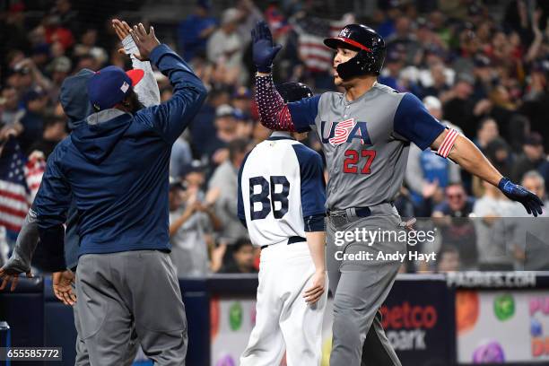 Giancarlo Stanton of Team USA is congratulated by teammates after hitting a two-run home run in the top of the fourth inning of Game 6 of Pool F of...