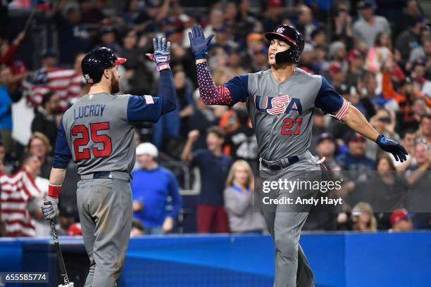 Giancarlo Stanton of Team USA is congratulated by teammate Jonathan Lucroy after hitting a two-run home run in the top of the fourth inning of Game 6...