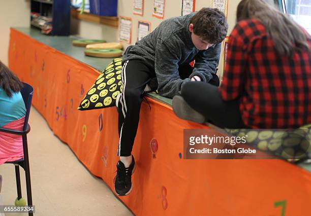 At Nettle Middle School in Haverhill, MA, Casey Decoteau sits on a pillow on a window bench during class on Mar. 10, 2017. Teachers are increasingly...