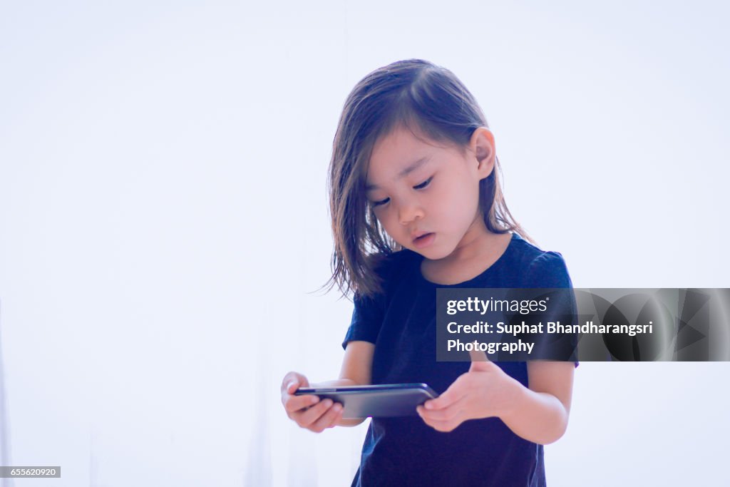 Toddler watching cartoon near window