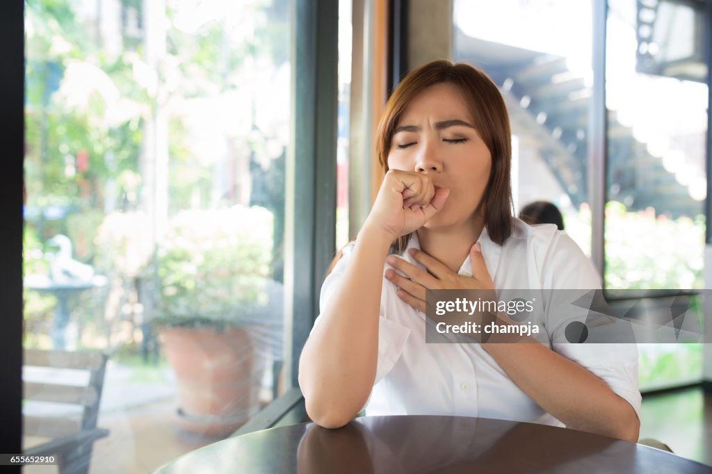 Woman has sore throat at coffee shop