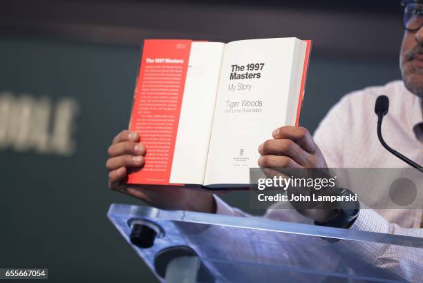 Fans pose with a book as professional golf player, Tiger Woods signs copies of his new book "The 1997 Masters: My Story" at Barnes & Noble Union...