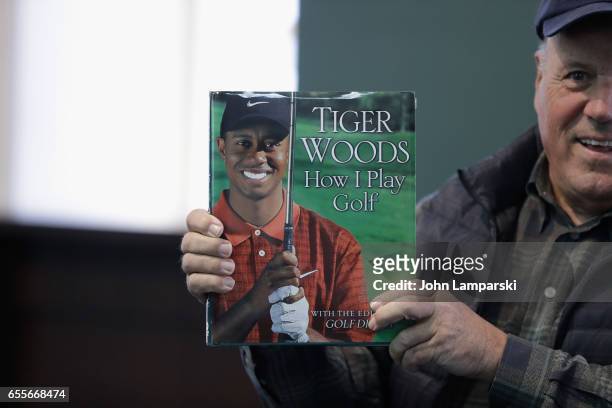 Fans pose with a book as professional golf player, Tiger Woods signs copies of his new book "The 1997 Masters: My Story" at Barnes & Noble Union...