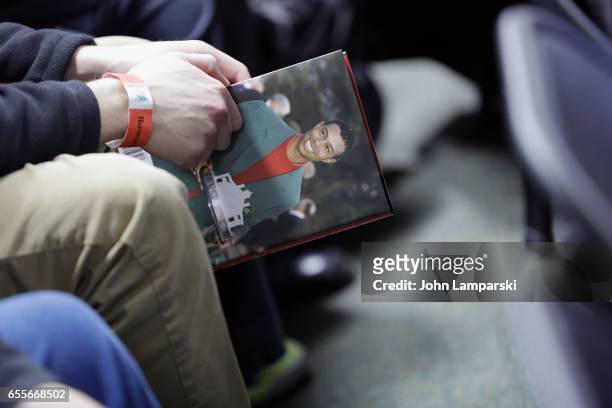 Fans pose with a book as professional golf player, Tiger Woods signs copies of his new book "The 1997 Masters: My Story" at Barnes & Noble Union...