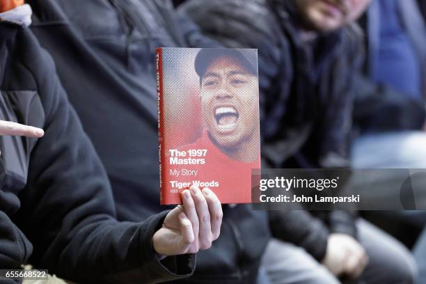 Fans pose with a book as professional golf player, Tiger Woods signs copies of his new book "The 1997 Masters: My Story" at Barnes & Noble Union...