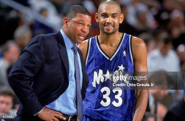 Grant Hill of the Orlando Magic smiles and looks on with Head Coach ''Doc'' Rivers during the game against the Seattle SuperSonics at the Key Arena...