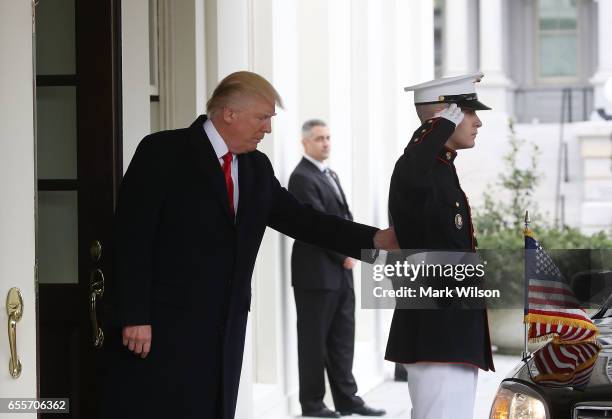 President Donald Trump waits in the doorway of the West Wing to greet Iraqi Prime Minister Haider al-Abadi for a meeting at the White House, on March...