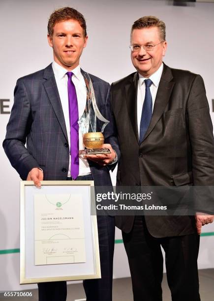 Julian Nagelsmann, the head coach of TSG 1899 Hoffenheim, gets the award 'Coach Of The Year 2016' from DFB president Reinhard Grindel on March 20,...