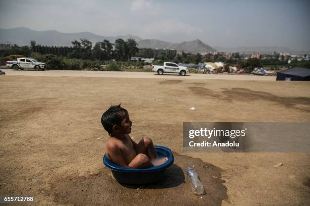 Boy, who is a flood victim, is seen in a bucket in the Huachipa district, east of Lima, on March 20, 2017. Authorities in Peru have declared that the...